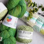 Assorted yarns and crochet tools arranged on a flat surface for a crafting session.