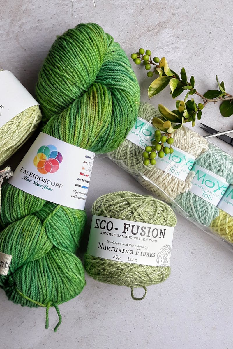 Assorted yarns and crochet tools arranged on a flat surface for a crafting session.