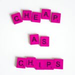 Colorful Scrabble tiles on white background spelling 'Cheap as Chips'